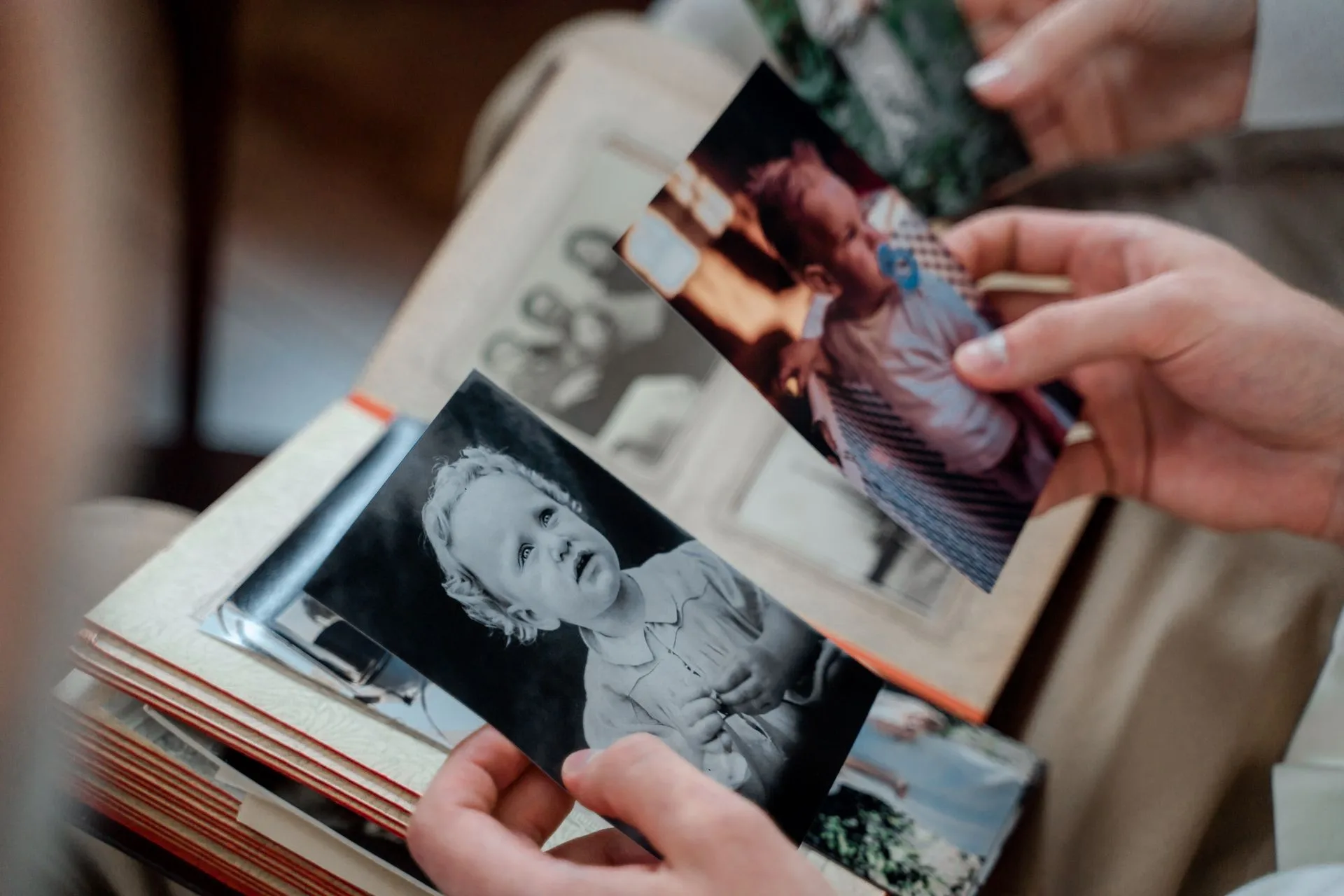 Mains feuilletant un album de photos de famille anciennes