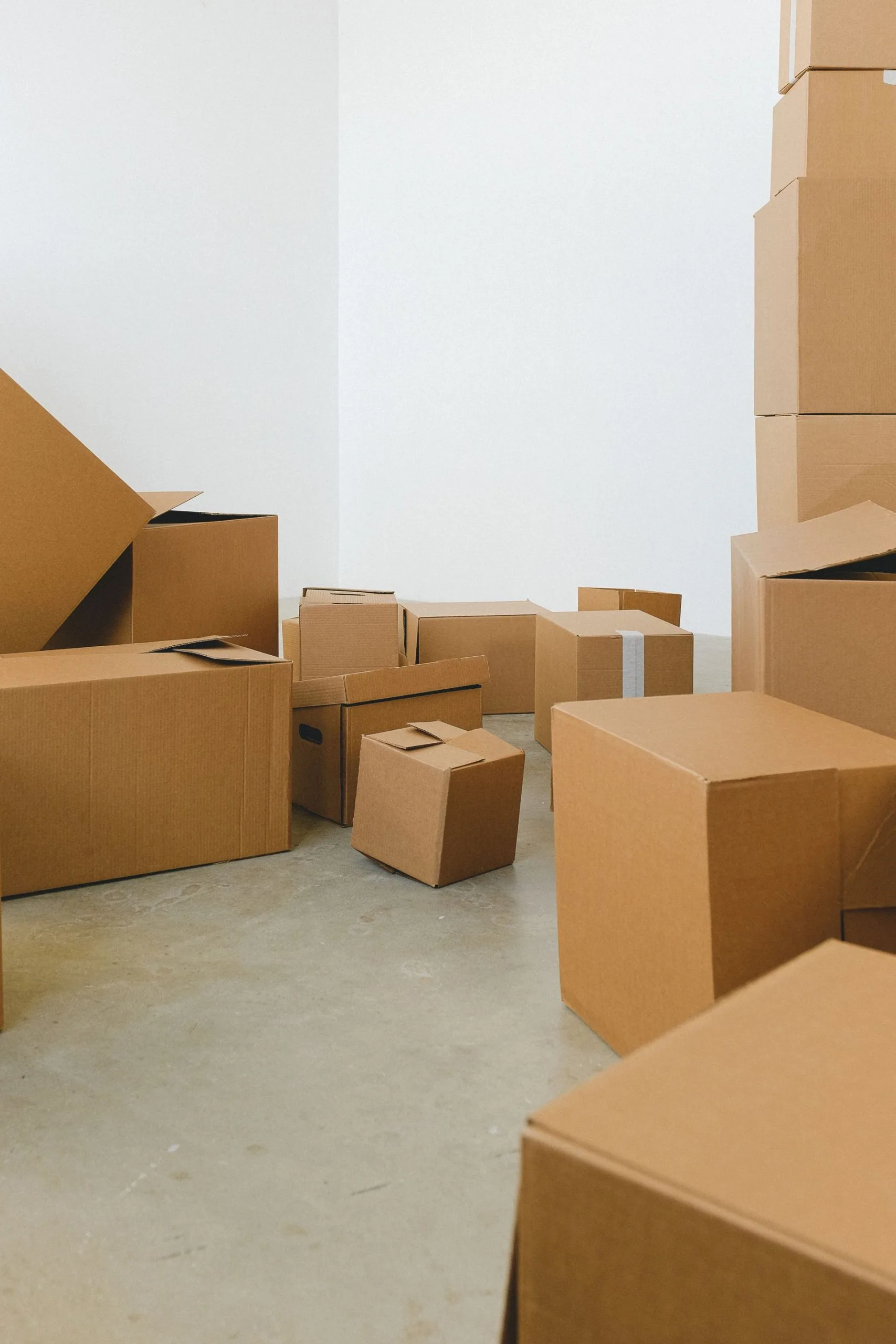Cartons de déménagement posés au sol d'une pièce blanche