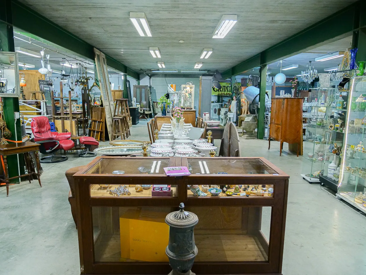Vue du dépôt avec comptoir-vitrine et table dressée en porcelaine