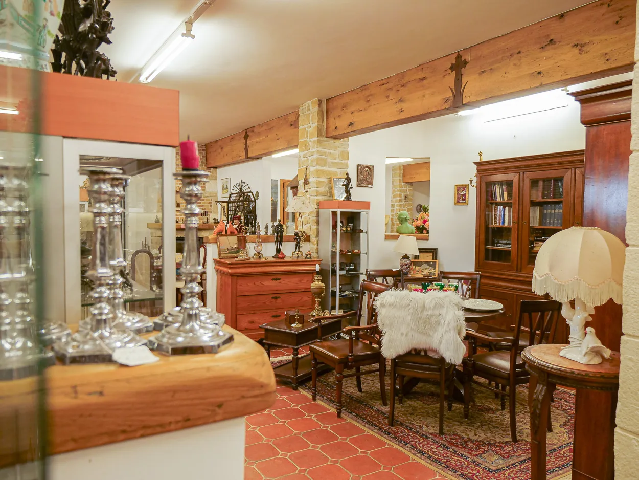Salle showroom cosy avec chandeliers, bibliothèque et mobilier de style