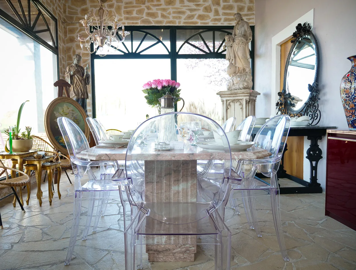 Table en marbre entourée de statues et vaisselle ancienne au dépôt