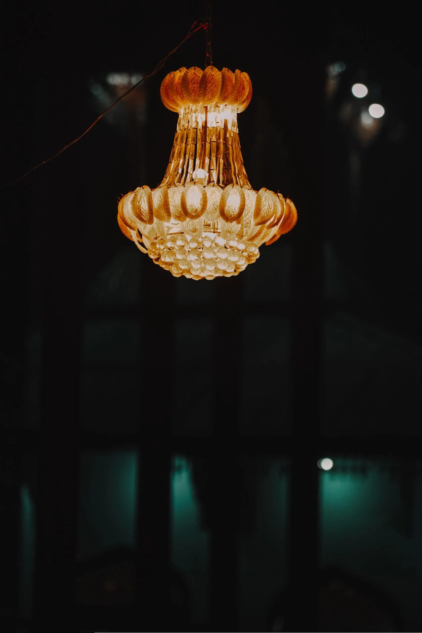 Lustre ancien diffusant une lumière chaude dans une pièce plongée dans la pénombre
