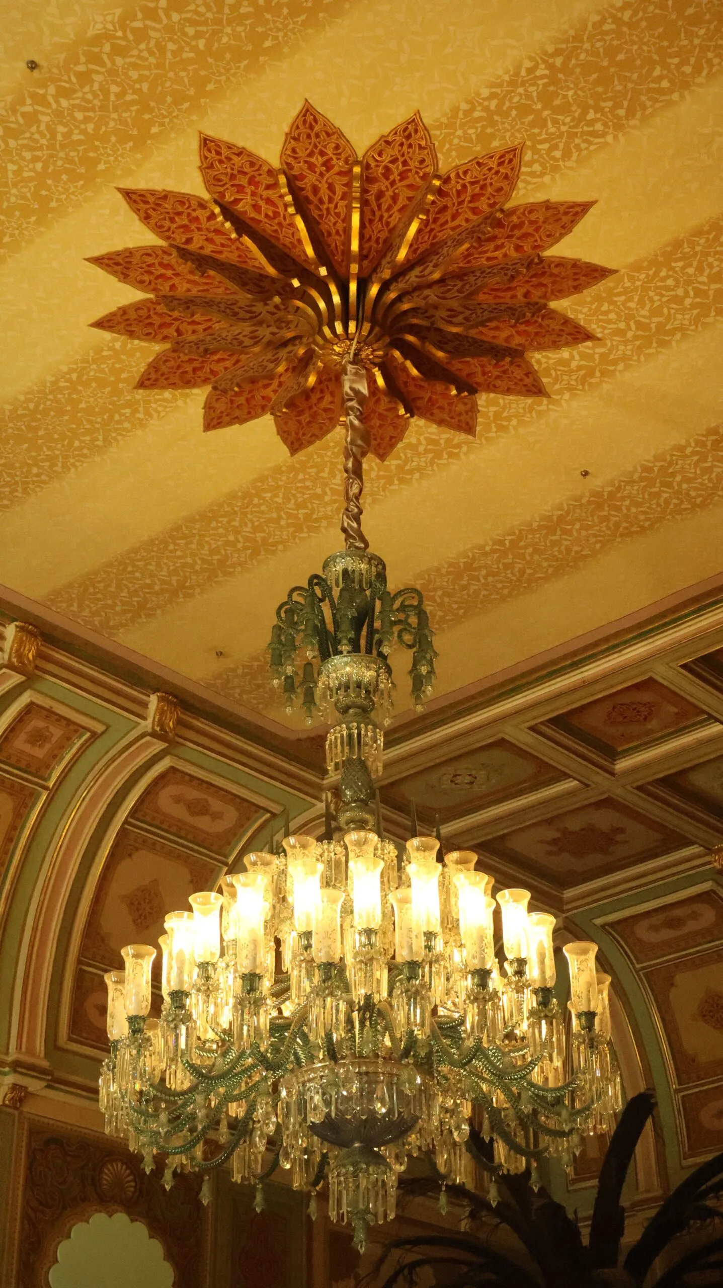 Lustre en cristal suspendu à un plafond richement décoré de style classique