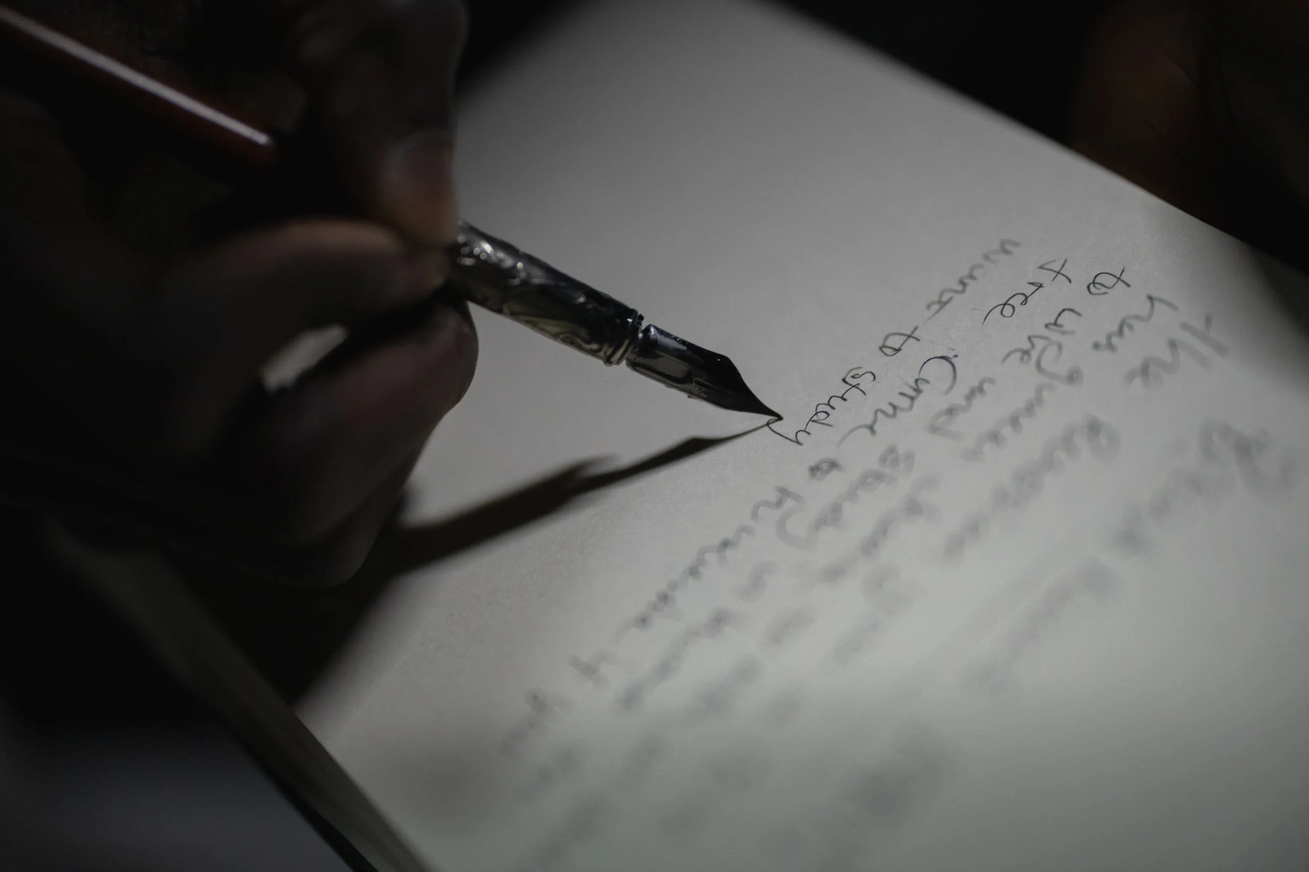 Main écrivant au stylo plume sur papier, geste soigné de prise de notes d'inventaire