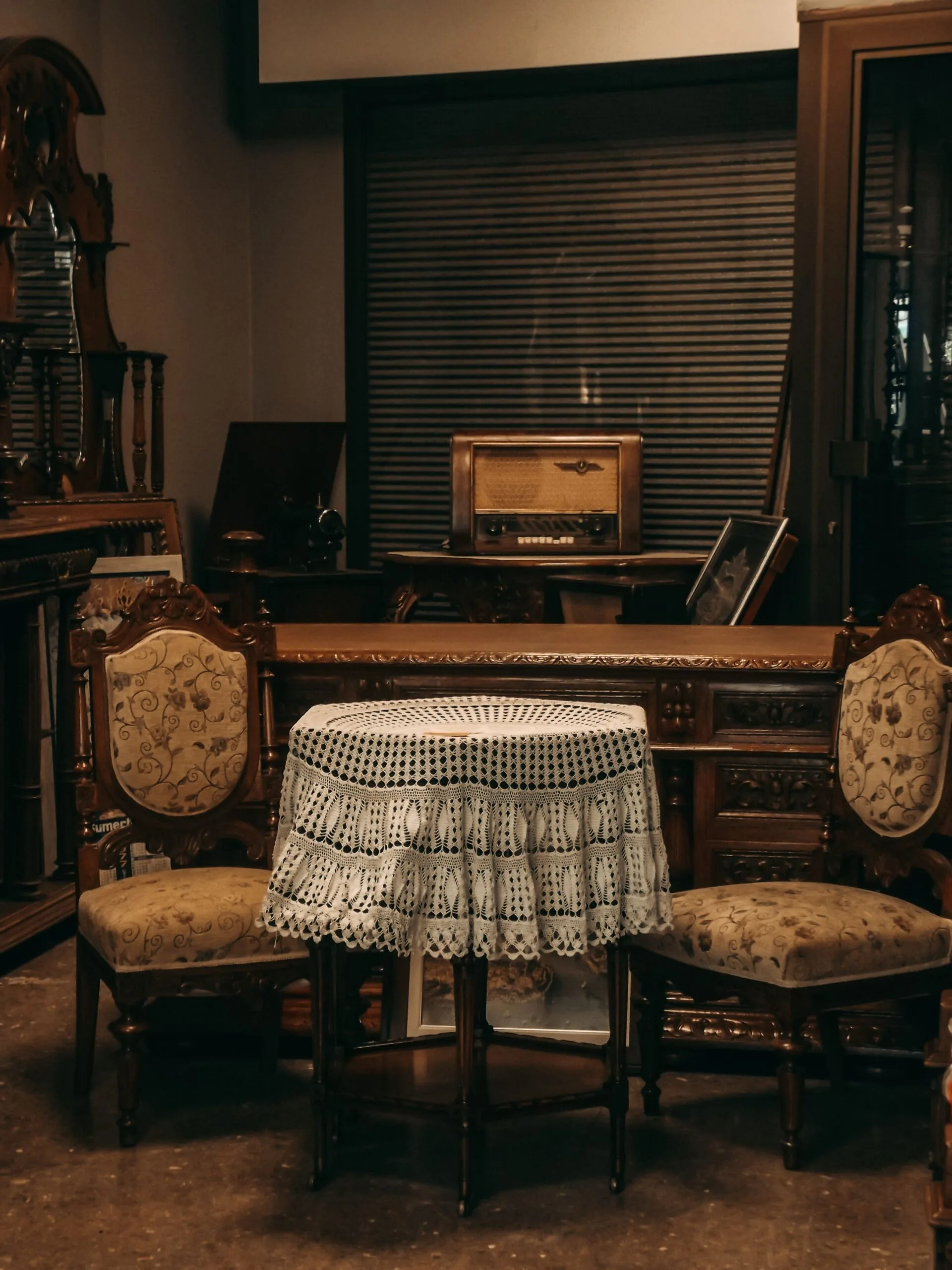 Salle à manger de maison de famille avec meubles anciens et table couverte de dentelle