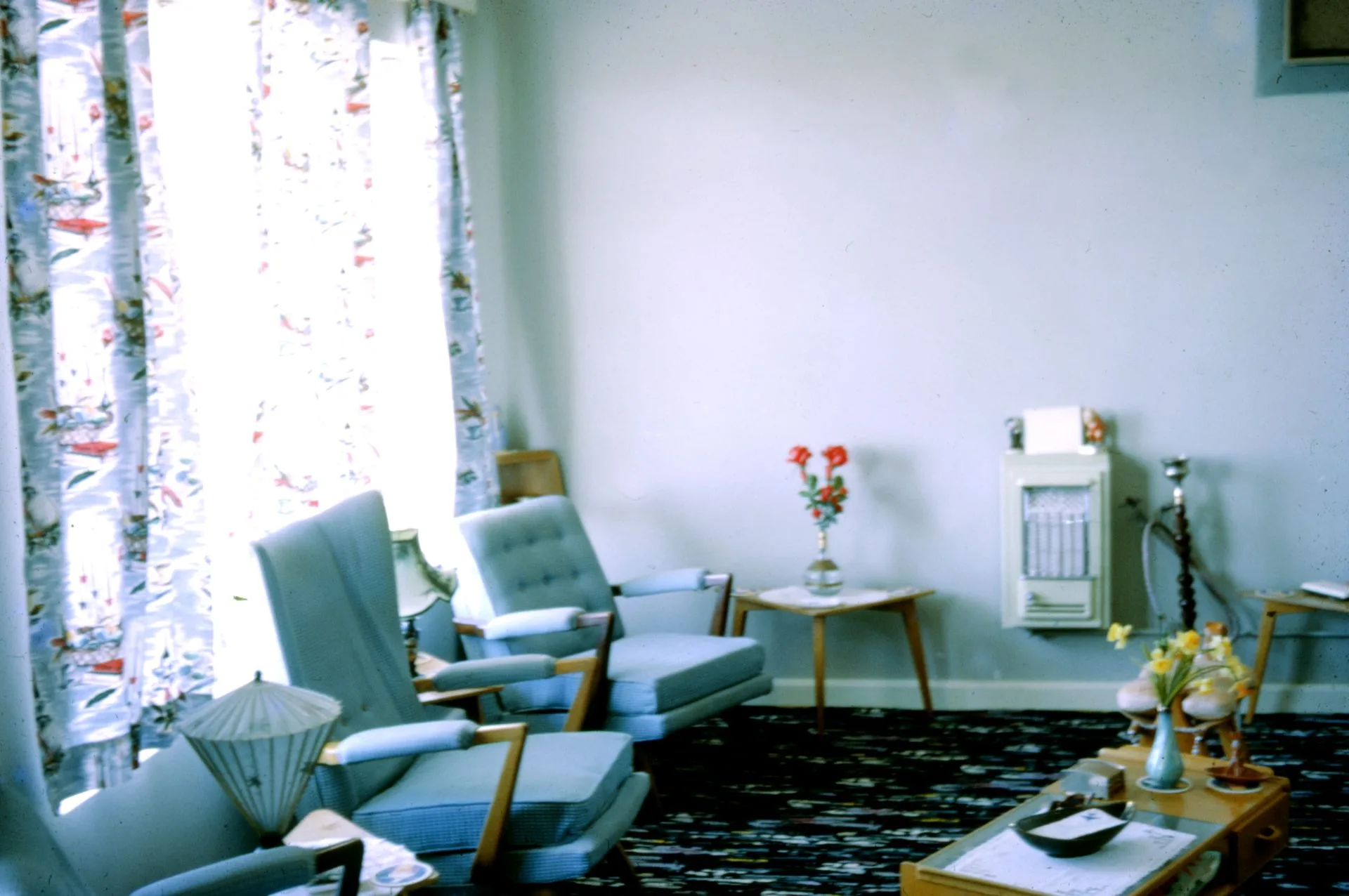 Salon rétro d'une maison de famille avec fauteuils et rideaux fleuris